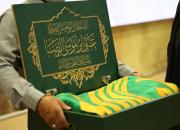  حضور خادمان امام رضا(ع) با پرچم متبرک حرم رضوی در نمایشگاه کتاب
